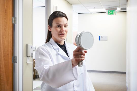 Staff in lab coat using RaySafe 452 Radiation Survey Meter