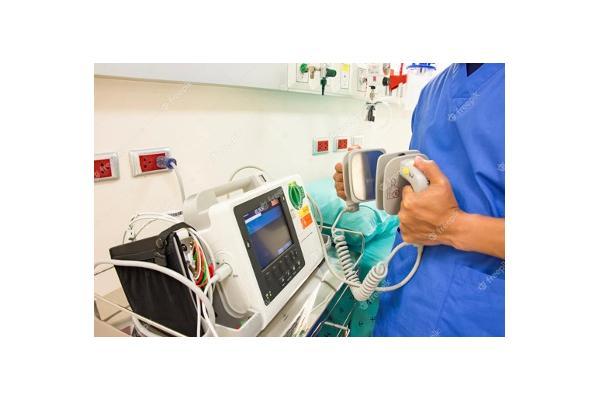 A doctor using a defibrillator